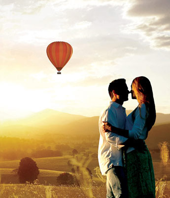Couple kissing with Hot Air Balloon in background