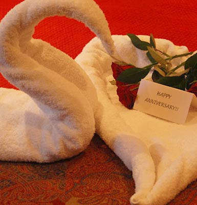 Folded swan towels with flowers and anniversary card