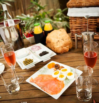 Champagne breakfast hamper laid out on table outside